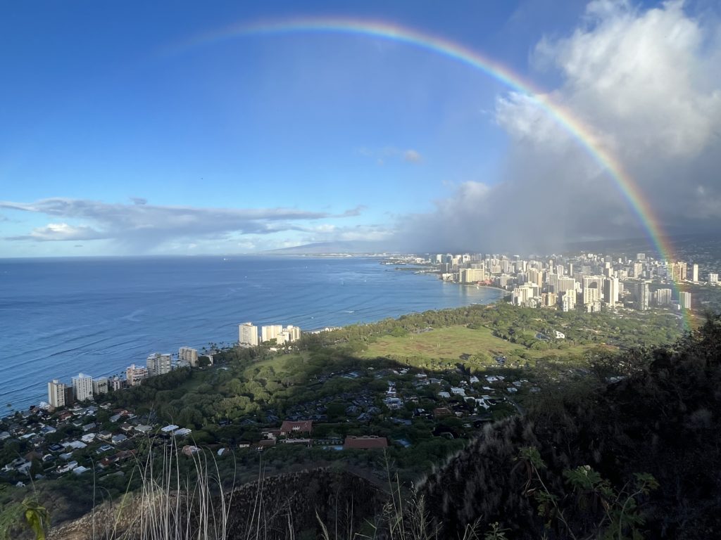 a rainbow over a city by the ocean