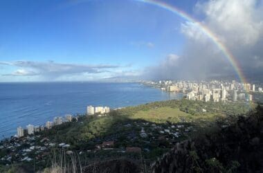 a rainbow over a city by the ocean