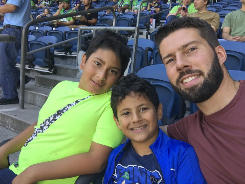 a man and two boys sitting in a stadium