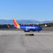 a blue airplane on a runway