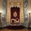 a throne in a room with marble walls and a marble floor