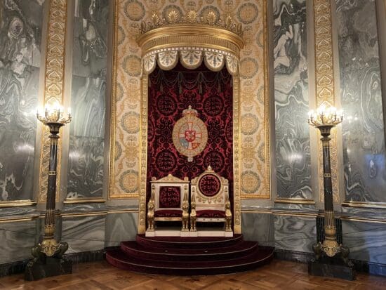 a throne in a room with marble walls and a marble floor