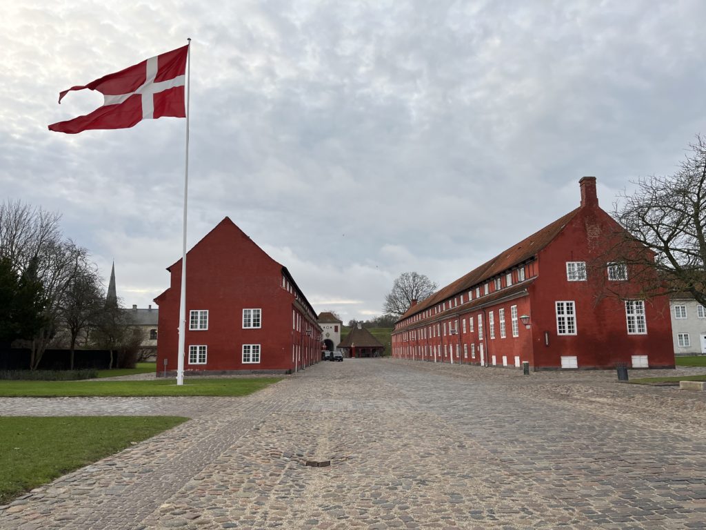 a red building with a flag on a pole