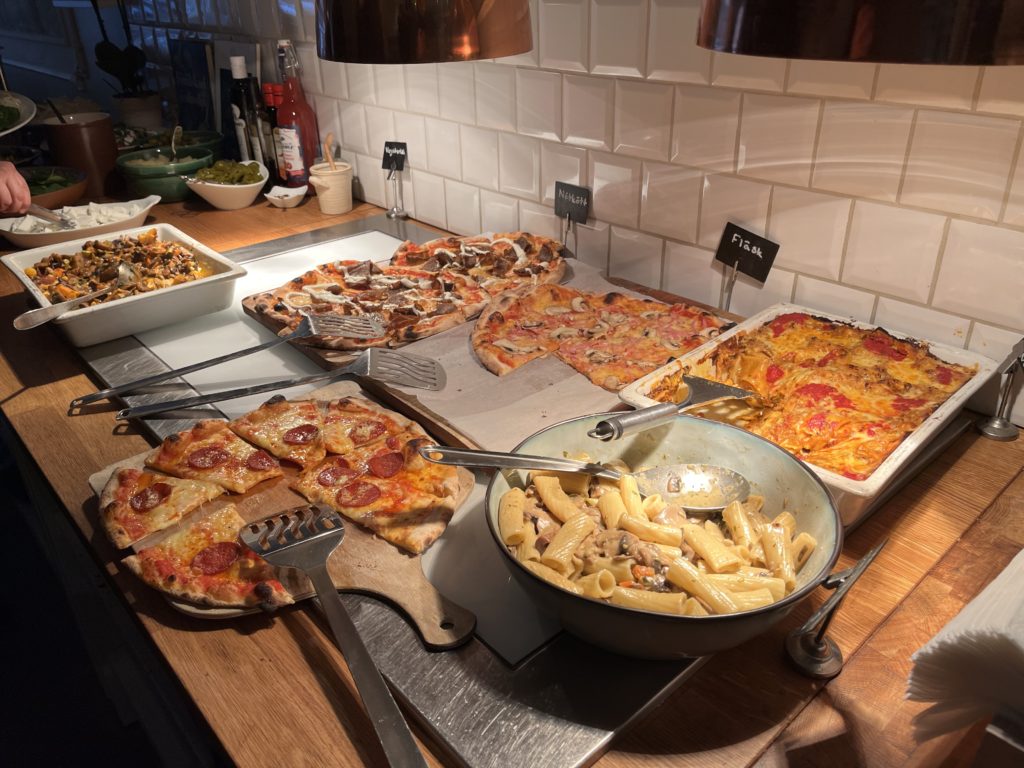 a table full of pizzas and pasta