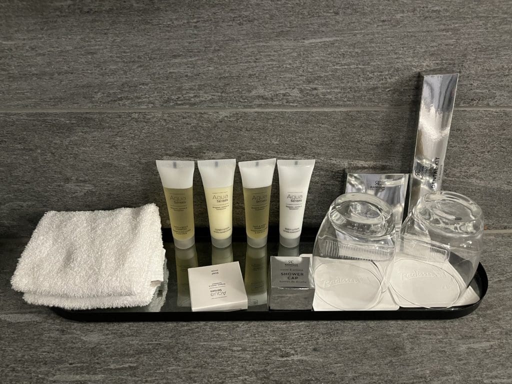 a group of toiletries and towels on a black tray