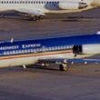 a blue and white airplane on a runway