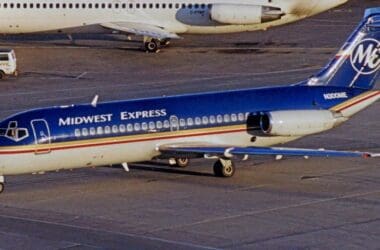 a blue and white airplane on a runway