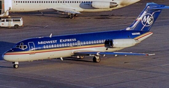 a blue and white airplane on a runway