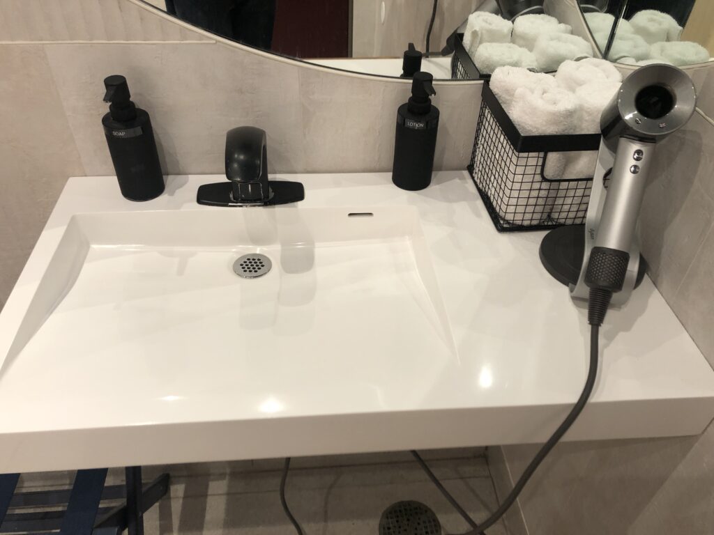 a bathroom sink with a hair dryer and a hairdryer