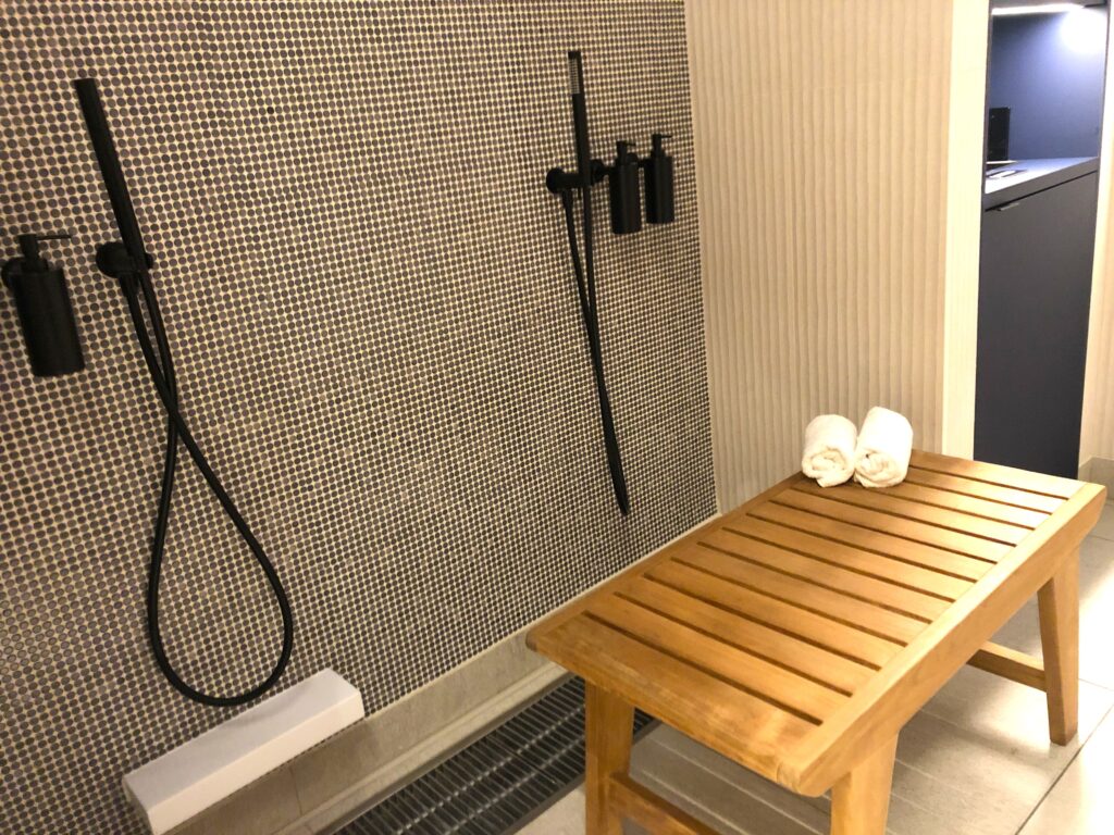 a shower with a bench and a shower head