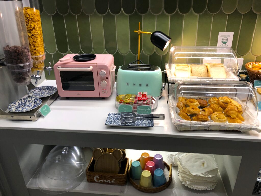 Pink and green toaster ovens, pastries, and dishes