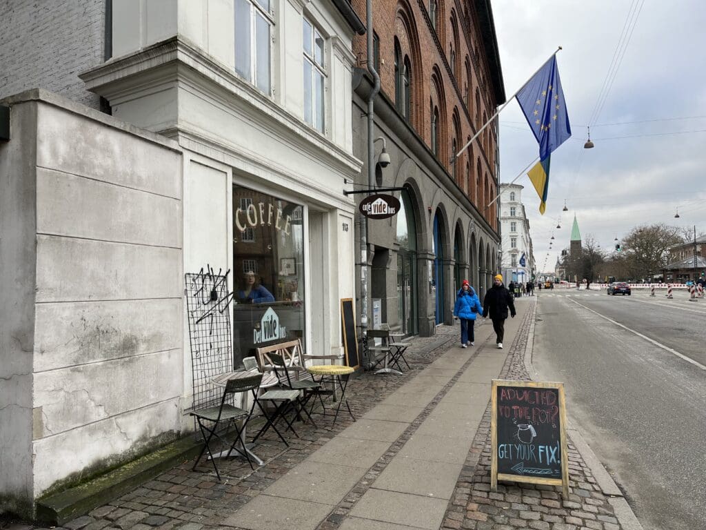 a sidewalk with chairs and flags on it