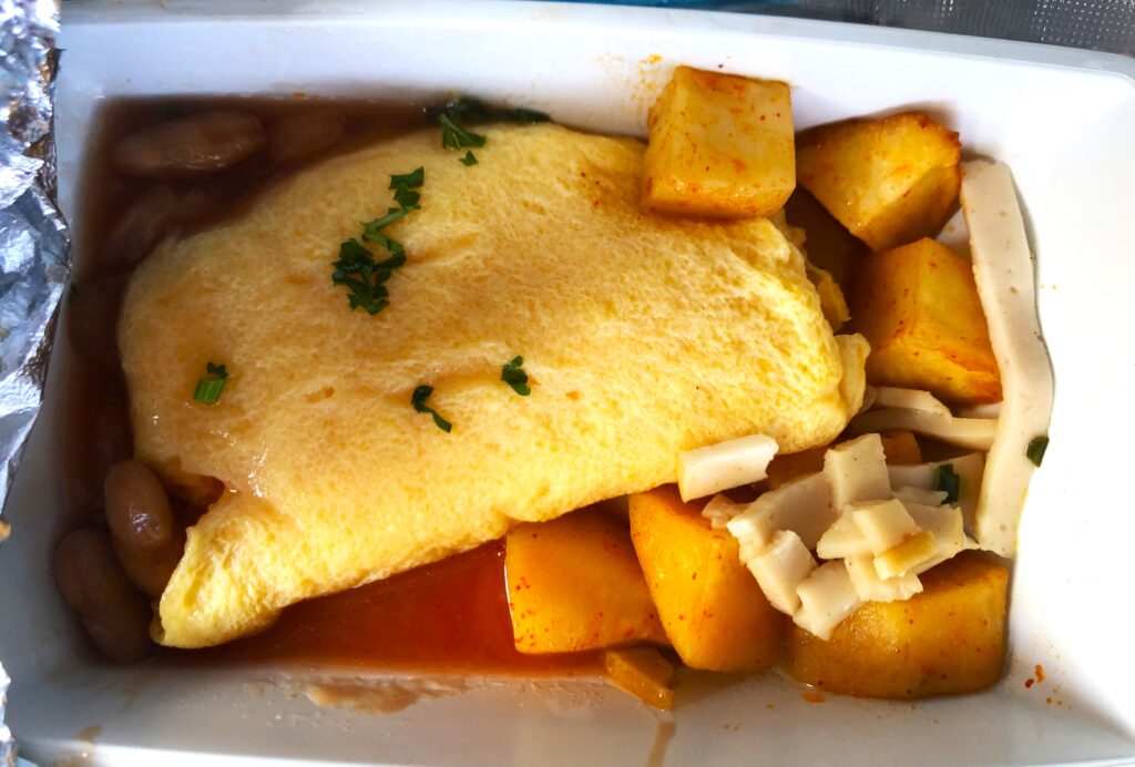 a plate of food with an omelette and potatoes