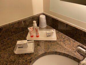 a bathroom counter with a tray of toiletries and other items