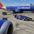 a blue airplane with a blue trailer on the ground