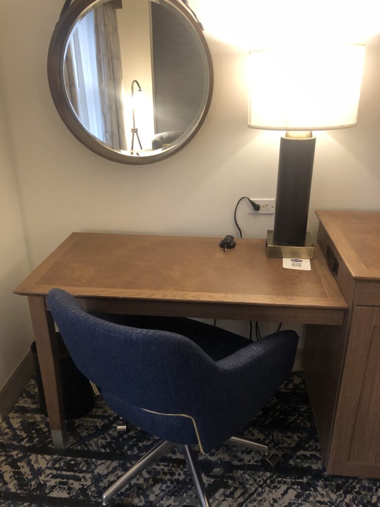 a desk with a lamp and a mirror