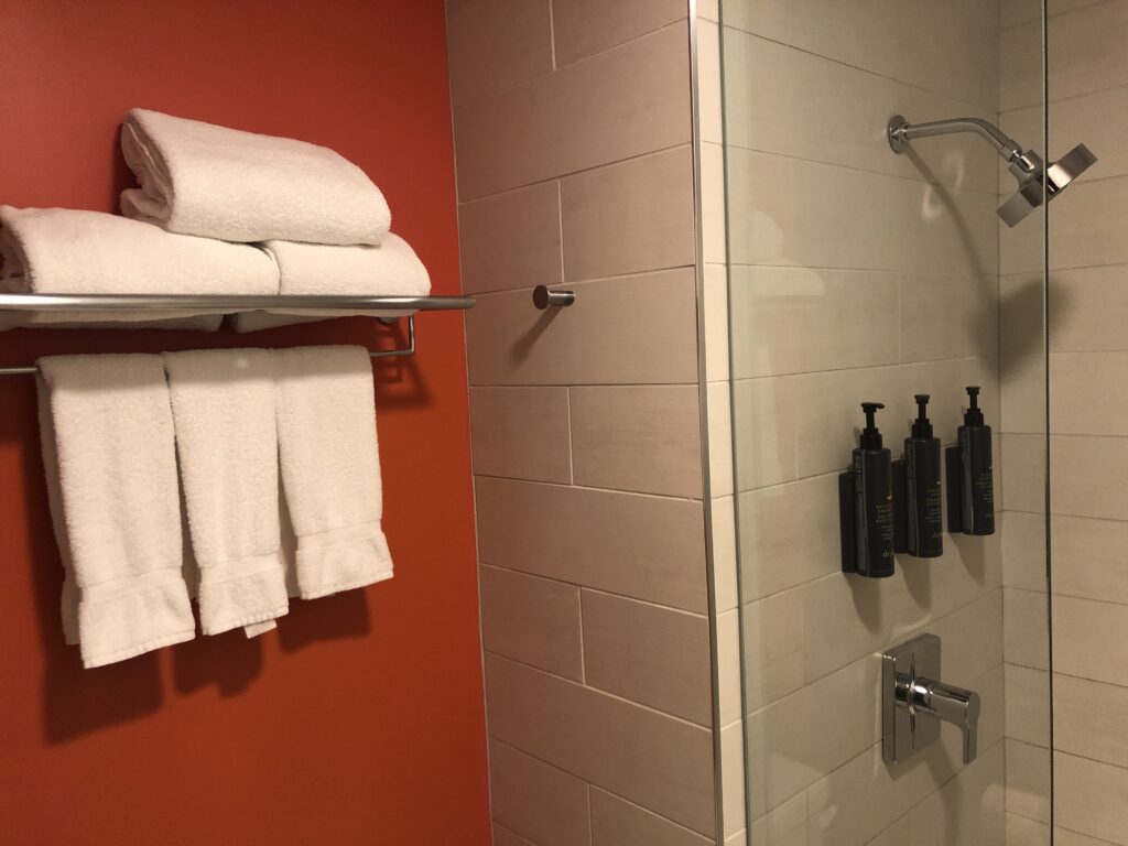 a shower with white towels and a shower head