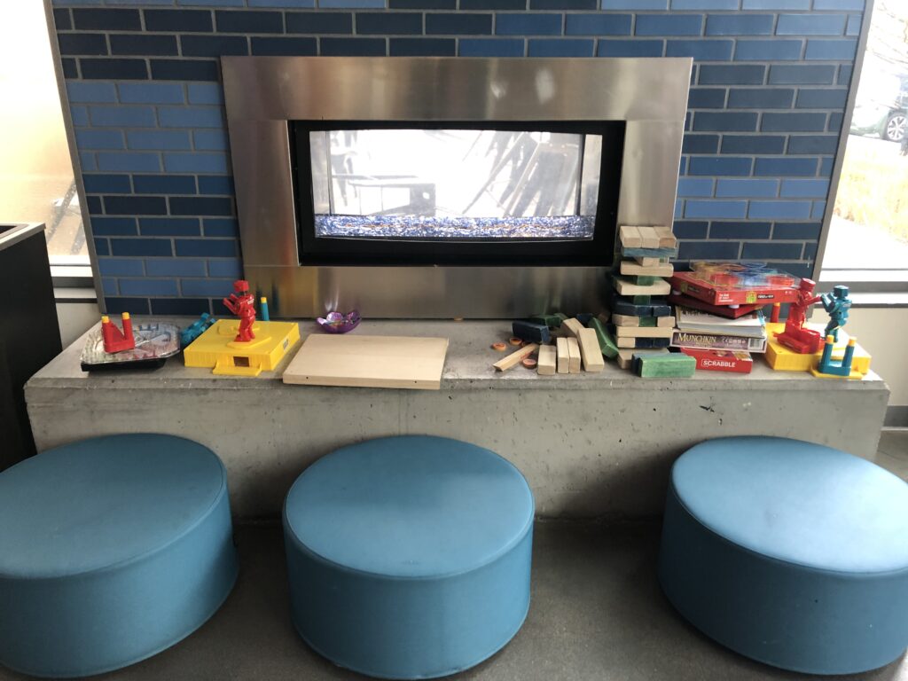a fireplace with blue stools and toys