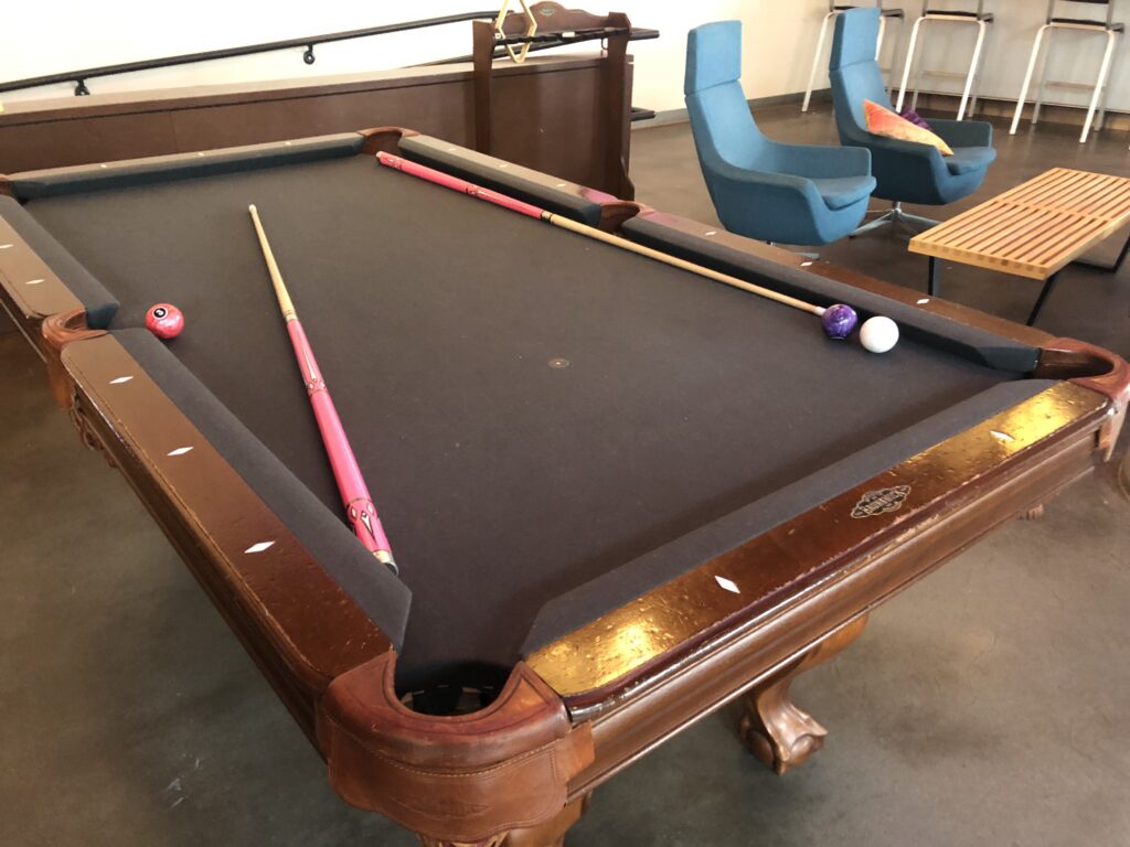 a pool table with cue sticks and a pool ball