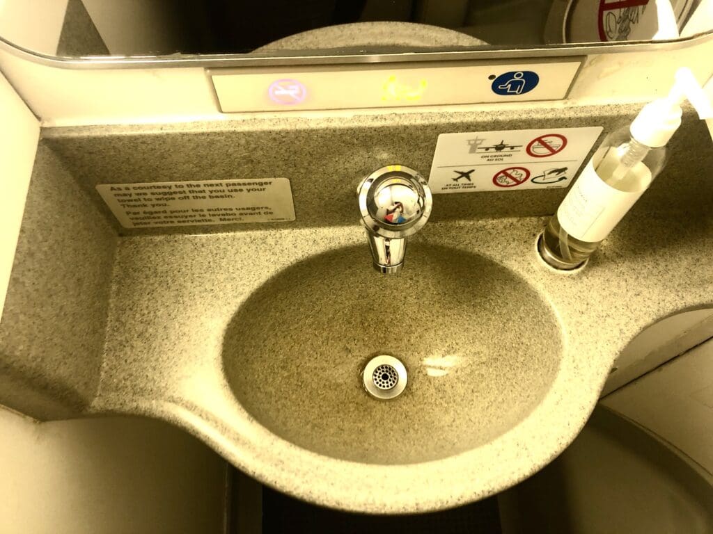 a sink with a faucet and a bottle of alcohol