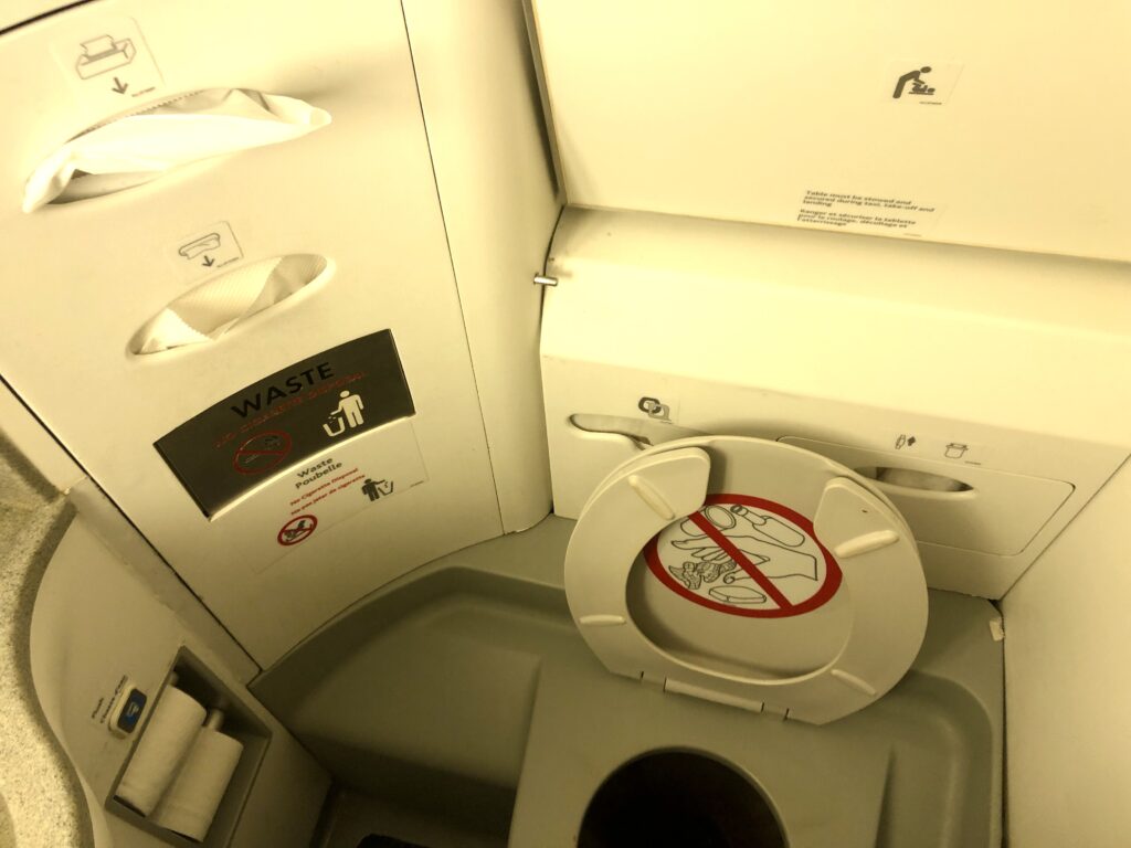 a toilet seat with a sign on the side