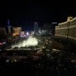 a city at night with a fountain in the middle