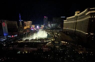 a city at night with a fountain in the middle