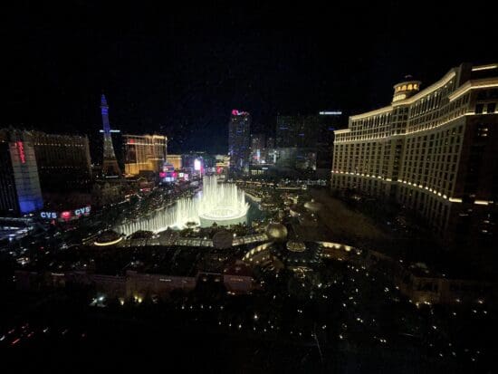 a city at night with a fountain in the middle