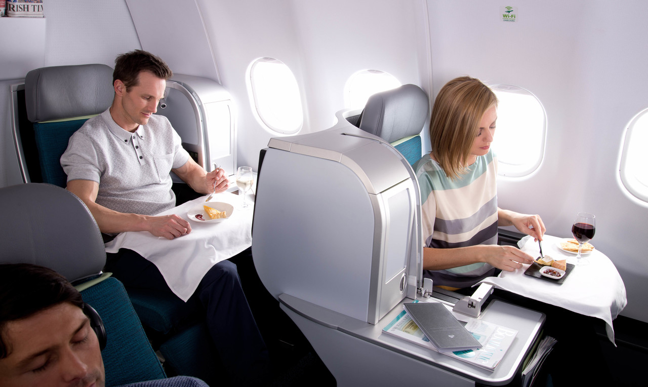 a man and woman sitting at a table in an airplane