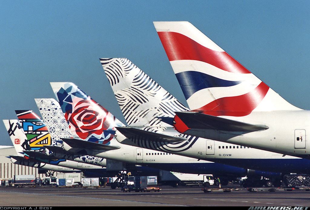 a row of airplanes with different designs on tail fin