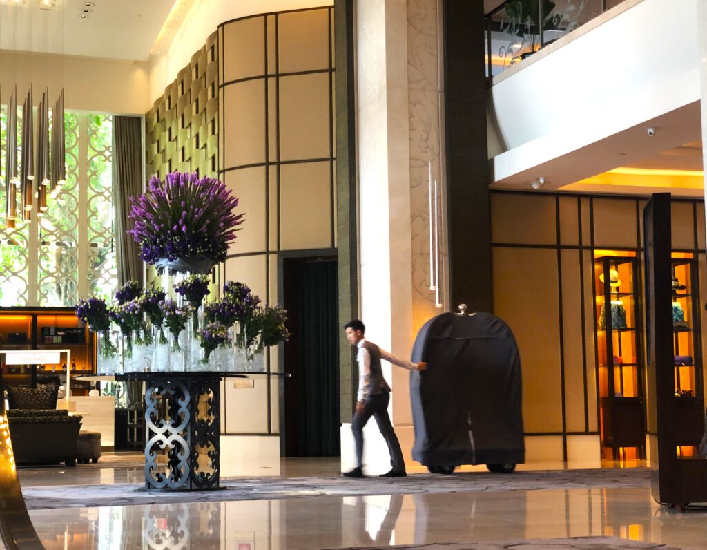 a man pushing a luggage cart in a hotel lobby