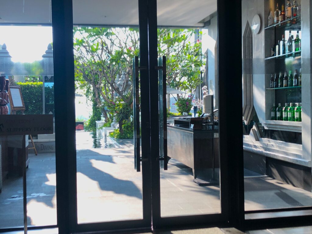 a glass door with a view of a building and trees