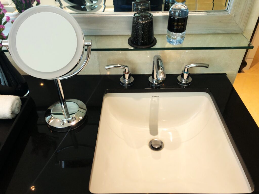 a sink with a mirror and a mirror on the counter