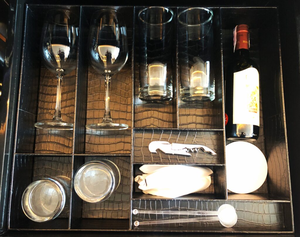 a wine bottle and glasses in a drawer