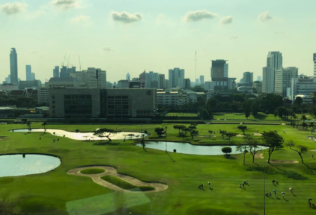 a golf course with water in front of a city