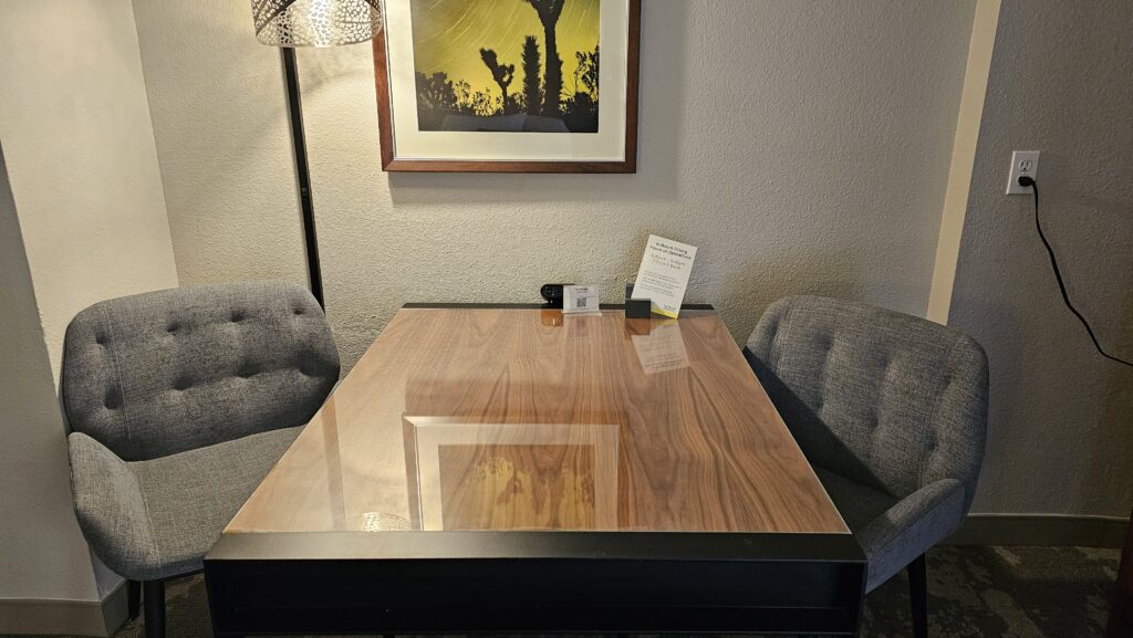 a table with a lamp and a picture on the wall