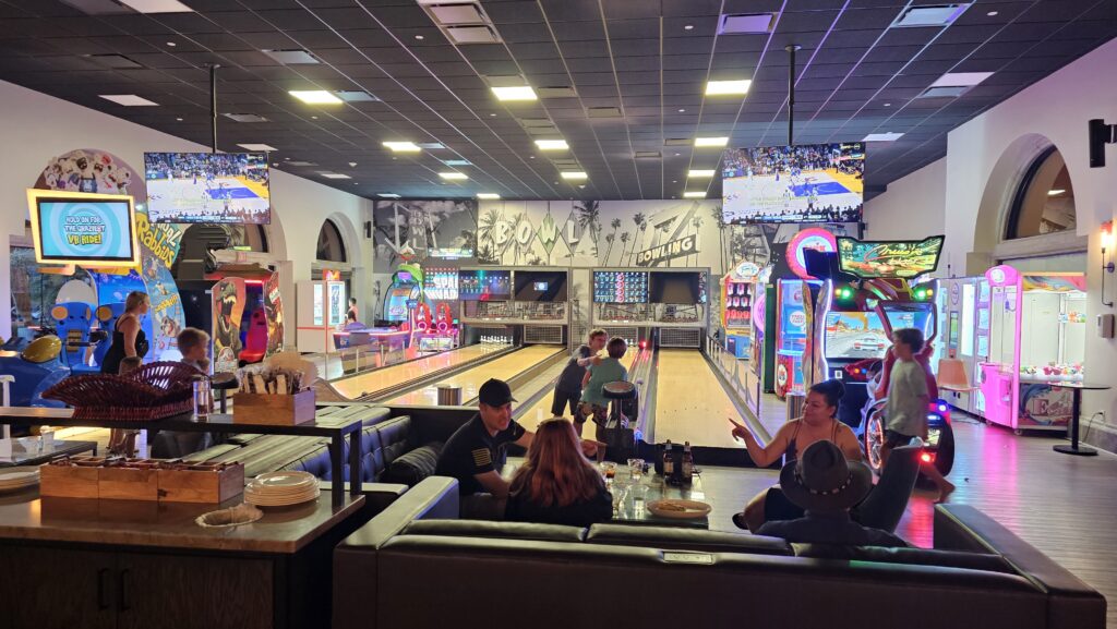 people sitting at a table in a bowling alley