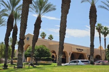 a building with palm trees and a parking lot