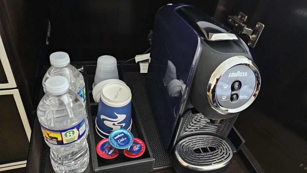 a coffee machine and cups and a container of coffee