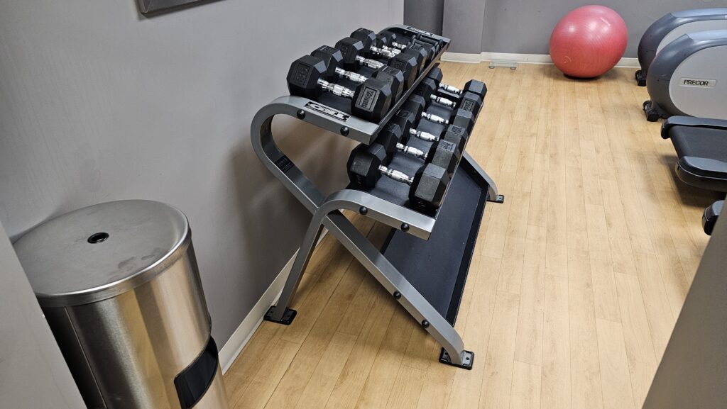 a rack of dumbbells on a wood floor