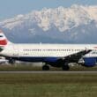 a plane on a runway with a snowy mountain in the background