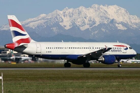 a plane on a runway with a snowy mountain in the background