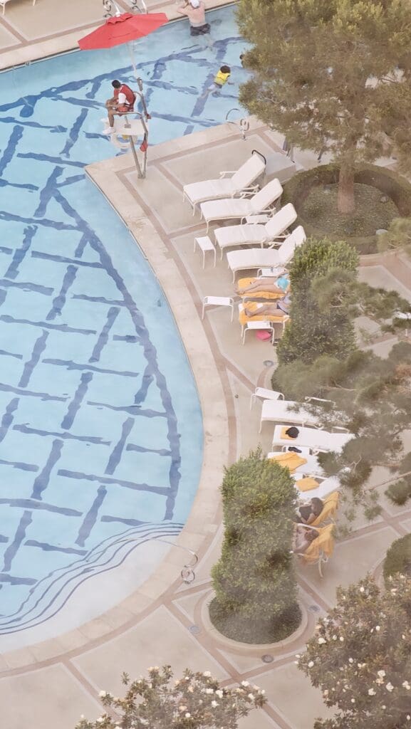 a pool with chairs and trees