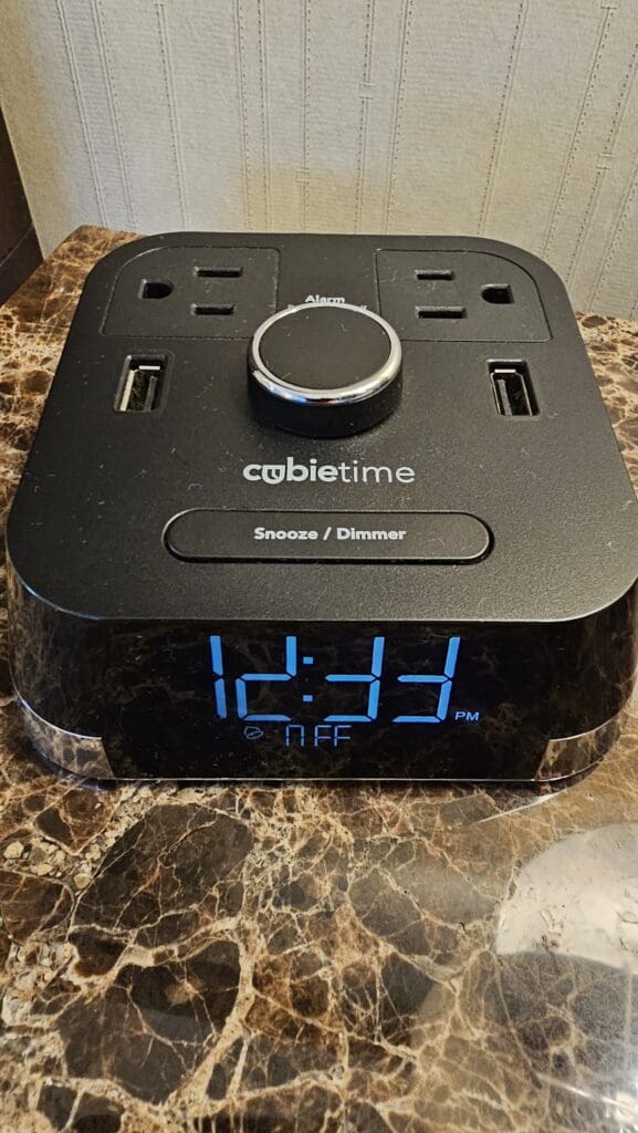 a black electronic clock on a marble surface