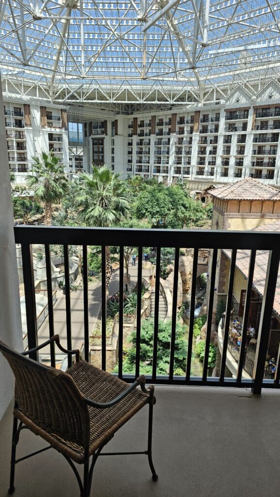 a balcony with a view of a large building and trees