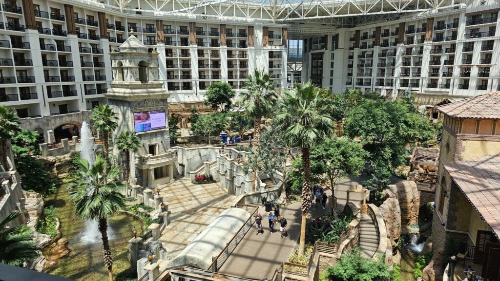 a courtyard with palm trees and a large building