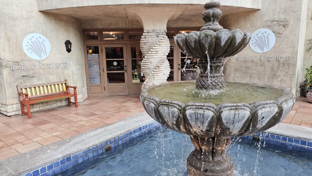 a stone fountain in front of a building