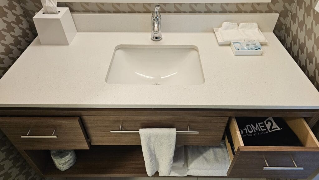 a sink with a drawer and towels