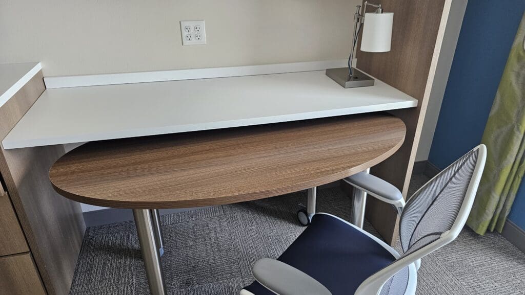 a desk with a lamp and chair