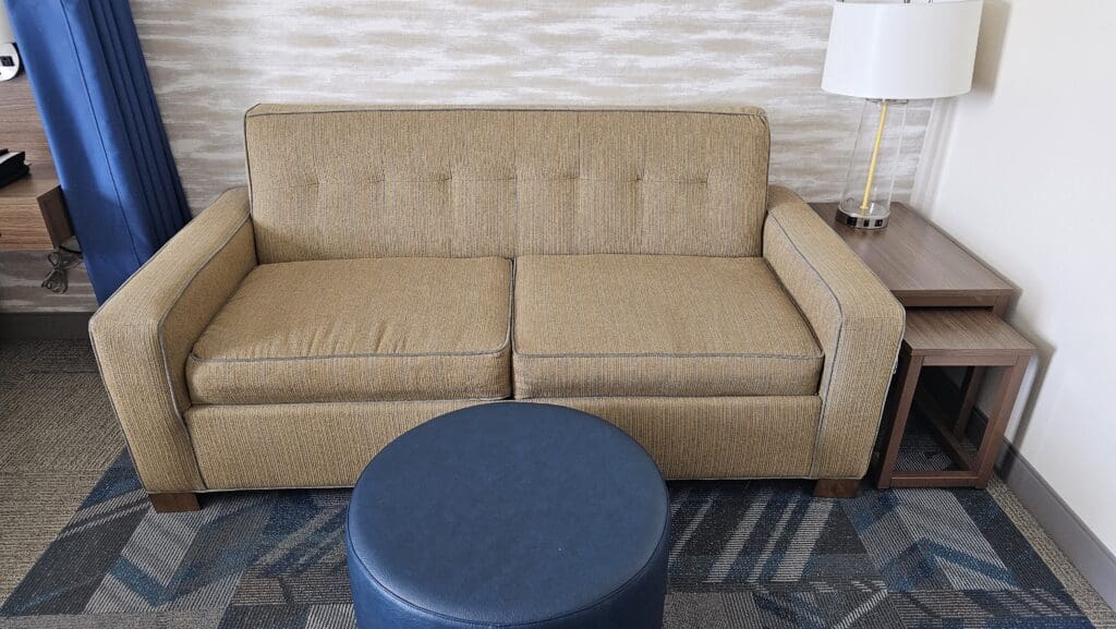 a couch and a round ottoman in a room